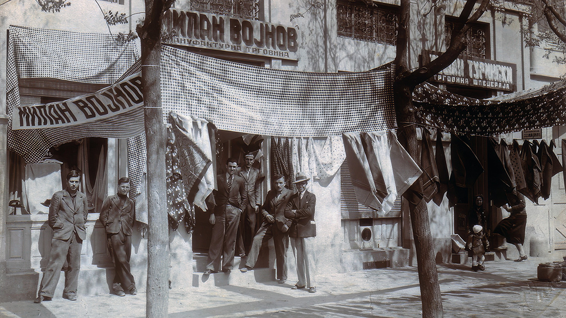 Trgovina manufakturama Milana Vojnova i trgovina špeceraja Dušana Turinskog na glavnoj ulici Novog Bečeja. Snimak iz perioda između dva Svetska rata.